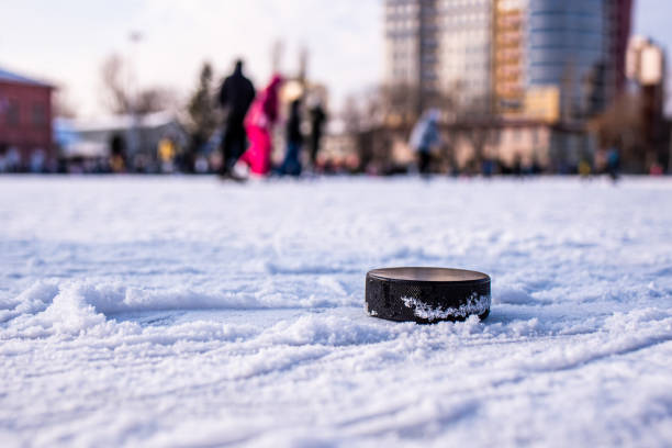 hockey puck lies on the snow macro - ice hockey hockey puck playing shooting at goal imagens e fotografias de stock