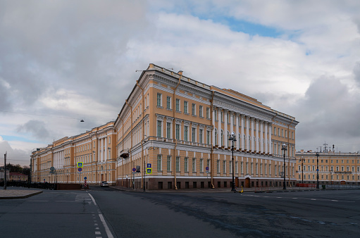 View of the east wing of the General Staff Building from the Moika River embankment on a summer day with clouds, St. Petersburg, Russia