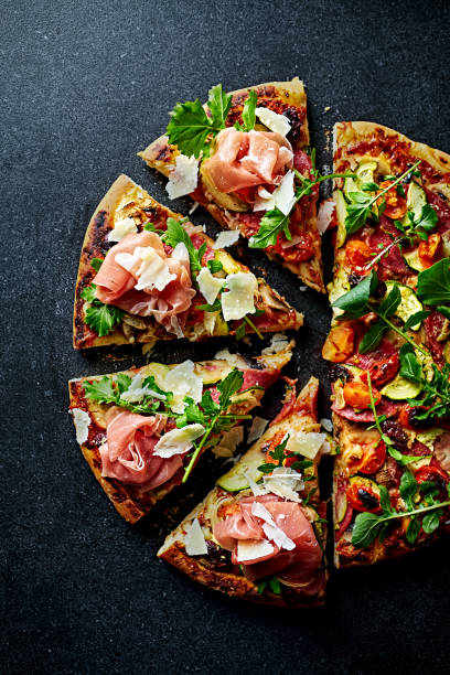 Pizza topped with serrano ham, arugula and grana padano cheese. Top view. stock photo