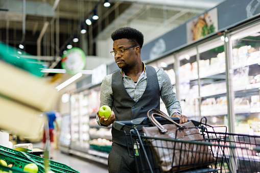 Man buying apples in supermarket