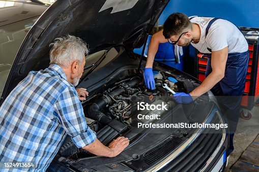 istock A Car Mechanic is Working on the Car Engine and Showing Problems to Senior Customer. 1524913654