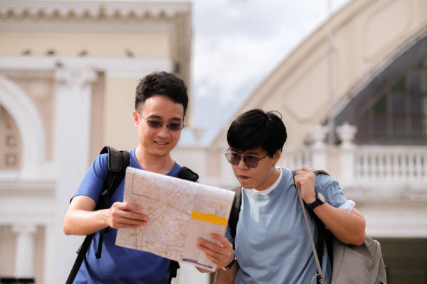 istock Asian handsome man looking at map with blur acient architecture train station blur behide. 1524920038