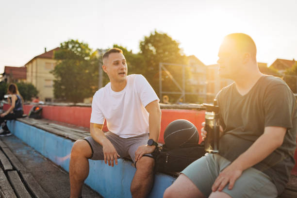 istock A man with a chromosomal disorder known as Down's syndrome is casually chatting with his best friend as he sits on a bench 1524923644