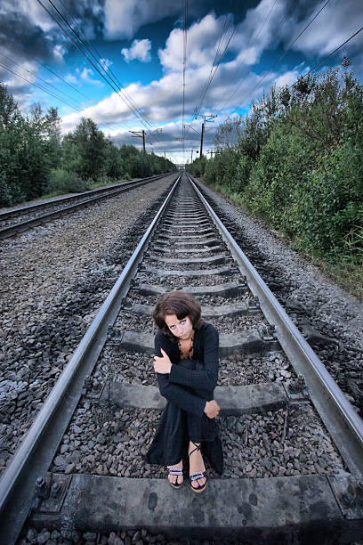 girl sits on railway stock photo