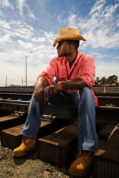 African-American Cowboy sitting on the Tracks stock photo