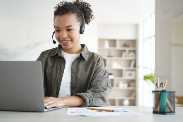 istock Smiling biracial high school student learns online at home, wearing headset for remote studying. Embracing distance education. 1524960730