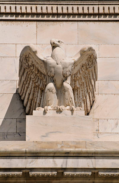 A stone eagle statue mounted on a building stock photo