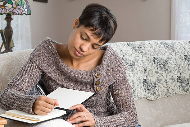 istock Young Woman Writing in Book 152497587