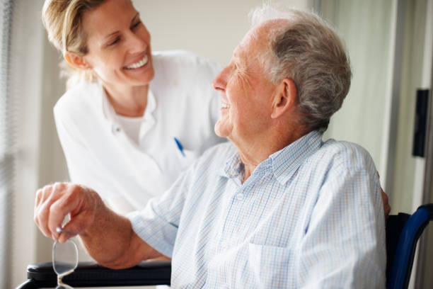 uomo anziano parlando a un infermiere - senior adult nursing home assisted living talking foto e immagini stock