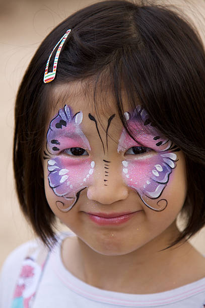 Girl with glitter butterfly face paint Asian Girl with butterfly face painting. Having a great time. asian eyebrows stock pictures, royalty-free photos & images