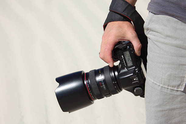 istock Hand holds photo camera and sand 152500095