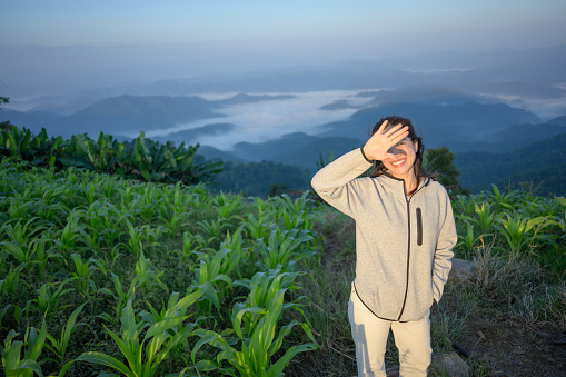 Active young woman wake up early sightseeing sunrise moment while traveling moment fog and mist on doi mon jam chiang mai thailand on her vacation