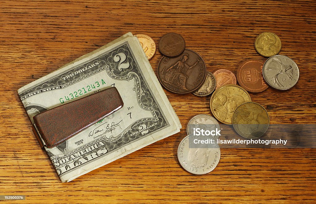 Money clip and coins Money clip with 2 dollar bill and foreign coins Business Stock Photo
