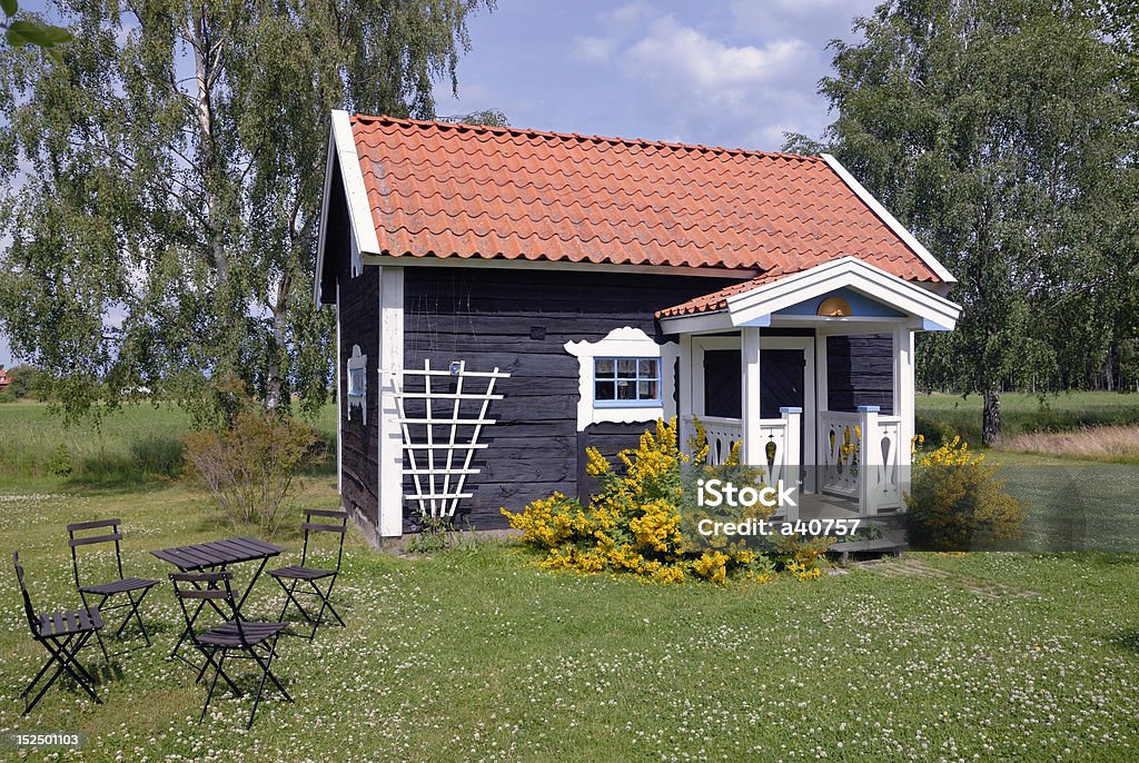 Summer house Small brown cottage by a green summer meadow. Log Cabin Stock Photo