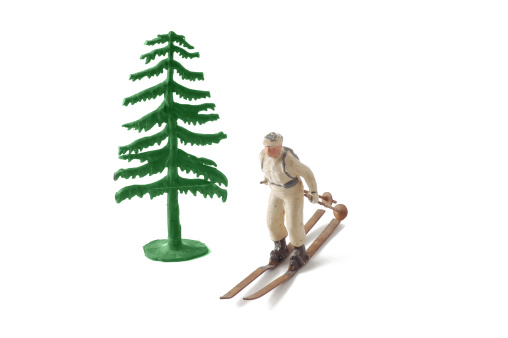 Miniature tree and skier isolated on white.