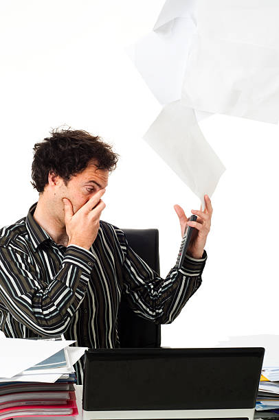 istock Man sitting at desk throwing up paperwork 152502084