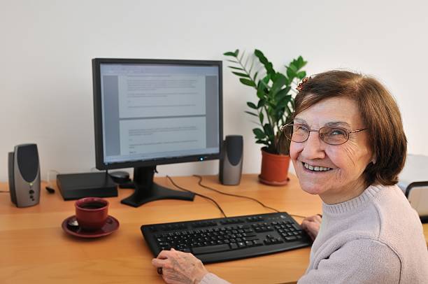 istock Smiling senior woman at computer 152502365