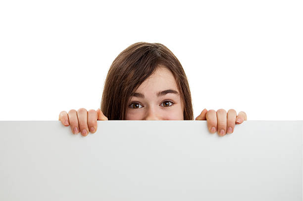 istock Girl peeking behind noticeboard 152502524