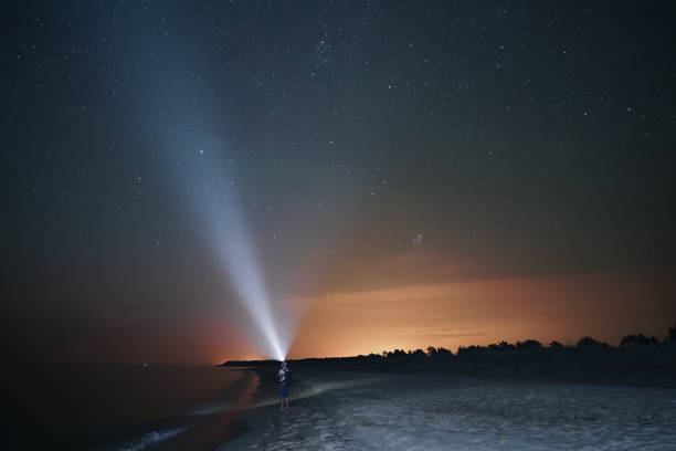 istock Man walks on the beach under the starry sky 1525036762