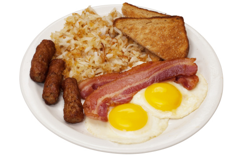 Breakfast plate with eggs sunny side up, bacon slices, link sausage, hash browns, and toast.  Isolated on white background with clipping path.