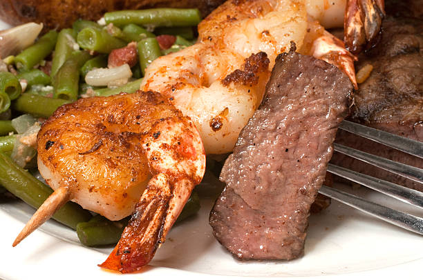 surf and turf - surf and turf prepared shrimp seafood steak photos et images de collection