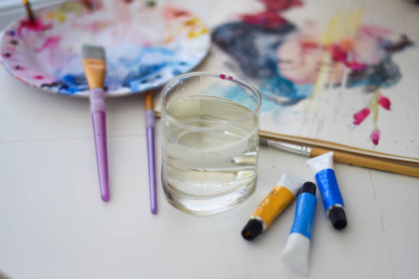 istock paint brushes and water on a table with and palette for art 1525045299