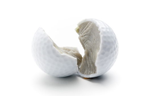 Broken golf ball on white isolated background