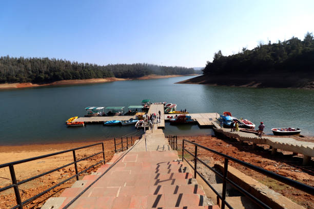 Beautiful lake landscape view under the beautiful clear sky with copy space in Ooty, Tamil Nadu, India also sailboats are tied up on river bank.