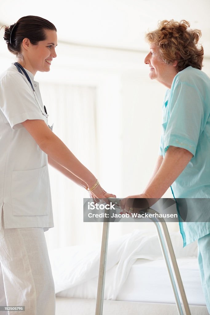 Femmina dottore aiutando il paziente con cornice zimmer - Foto stock royalty-free di Deambulatore
