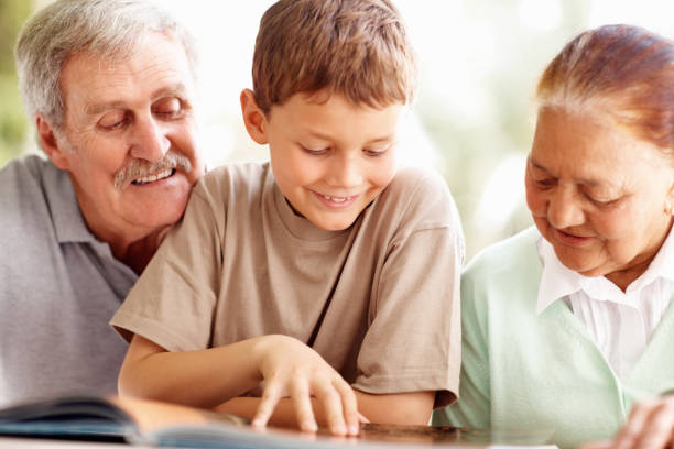 istock Grandparents with grandson reading a story book 152505804