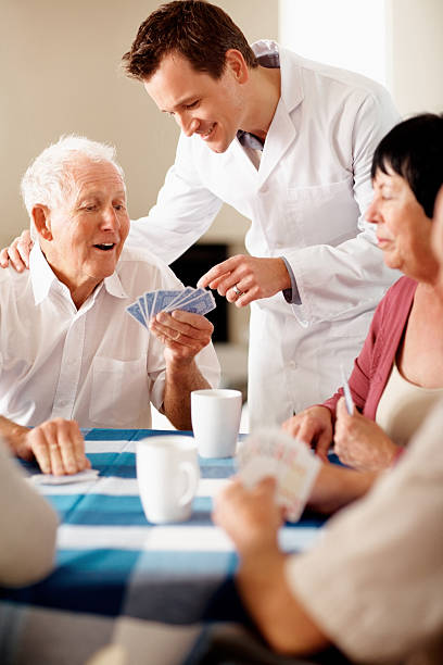 istock Happy doctor helping senior man while playing cards 152505807