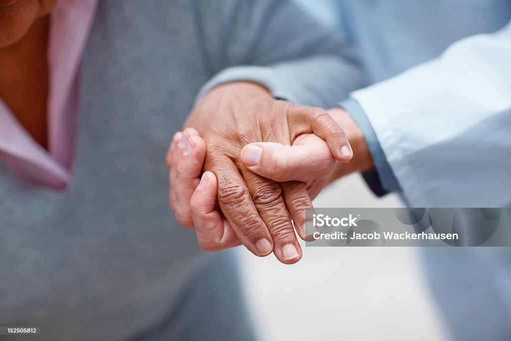 Medico tenendo la mano di un paziente - Foto stock royalty-free di Darsi la mano