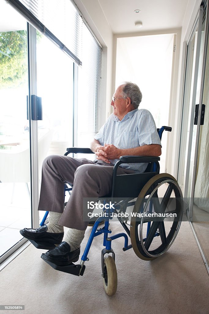Disabili senior paziente seduto su una sedia a rotelle - Foto stock royalty-free di 60-69 anni