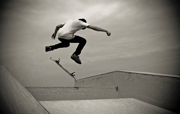 junger mann auf hardflip - extreme skateboarding action balance motion stock-fotos und bilder