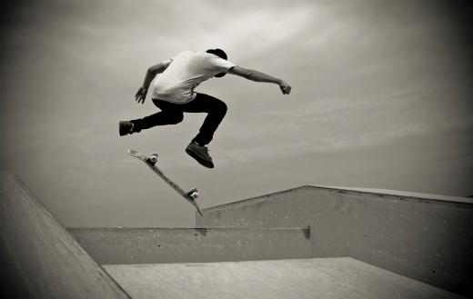 A young man jump on a skateboard in a skatepark