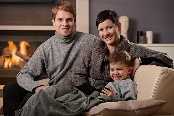 famille heureus'à la maison - blanket fireplace winter women photos et images de collection