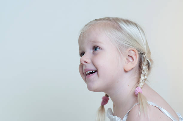 \\r\\nLittle girl in profile,looks smiling and surprised at something.\\r\\n
