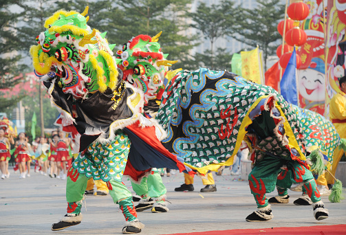 Chinese people playing lion dace on street during the lunar new year celebration.