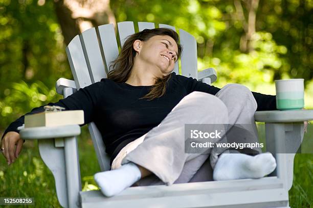 Woman Sitting In A Chair With Coffee Cup And Book Stock Photo - Download Image Now - 30-34 Years, Adirondack Chair, Adult