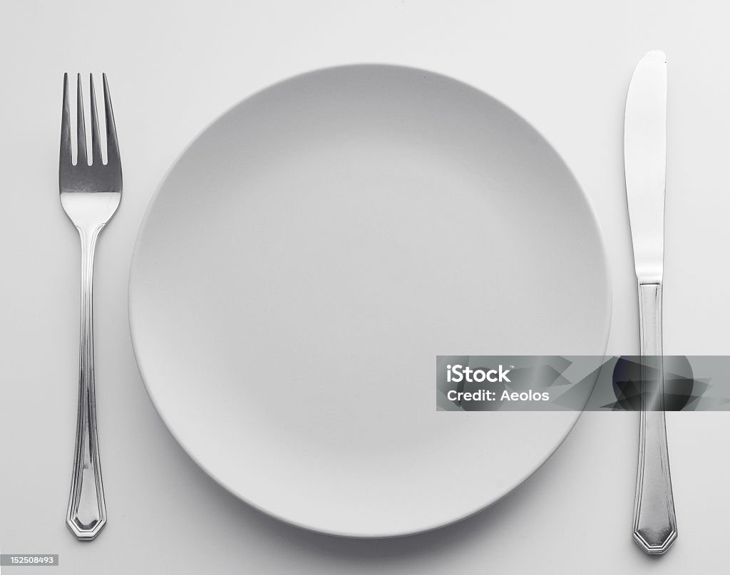 Fork, plate, and knife set out for dinner Cutlery set. black and white Backgrounds Stock Photo