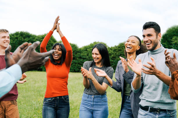 istock Happy group of people celebrating, clapping hands outdoors - Multiracial friends having fun together - Soft focus on center girl hands 1525111692
