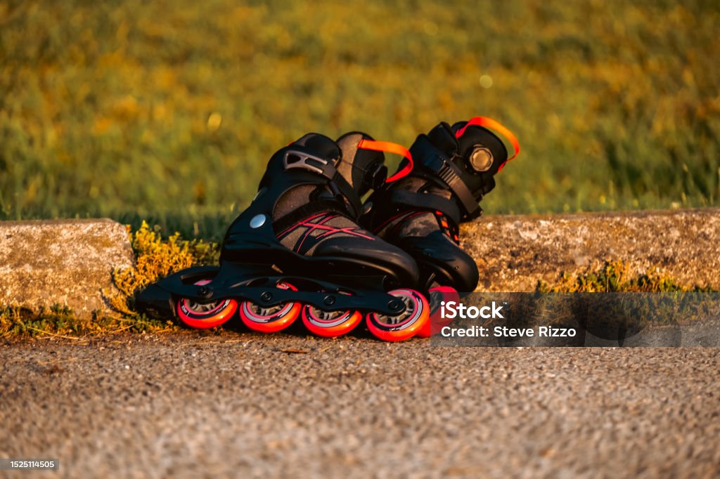 Inline Skates Rollerblade in the Park Outdoor Life active lifestyle Pair of Rollerblade in-line skates on pavement asphalt Athleticism Stock Photo