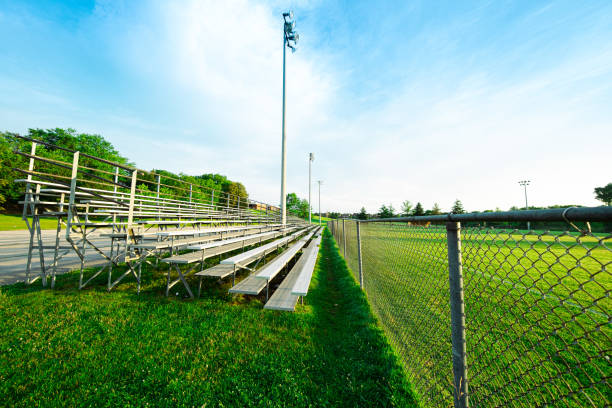 Early morning blue sky public park soccer and football grassy field bleachers