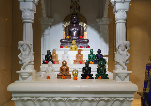 Bengaluru, Karnataka, India-April 28 2023; A Close up picture of a Jain temple with a group of Classical Gods or Monks in Meditating posture sculpted out of rare precious stone material in Bangalore, India.
