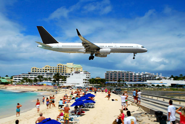 Plane Landing in St. Maarten Airport beach in St. Maarten, watch the planes don't hit you!!! saint martin caribbean stock pictures, royalty-free photos & images