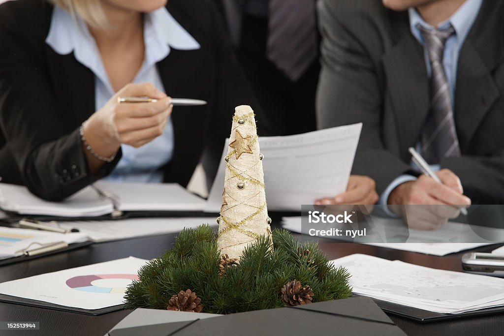 Cristmas decoration on meeting table Cristmas decoration on meeting table at office, business people talking in background. Focus placed on decoration in front. Click here for more Business images: Adult Stock Photo