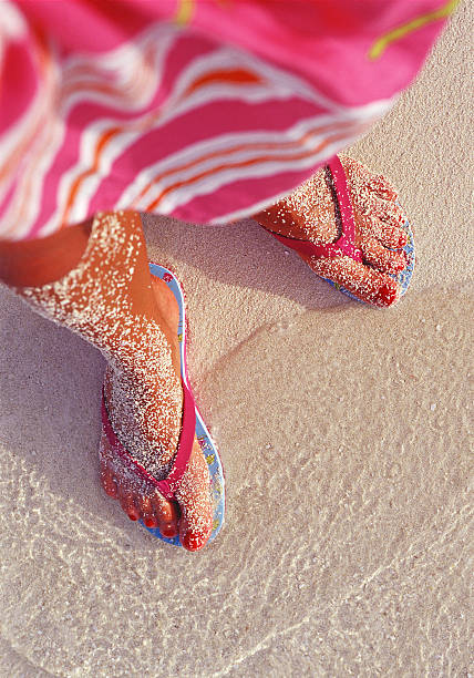woman's feet on the sand stock photo