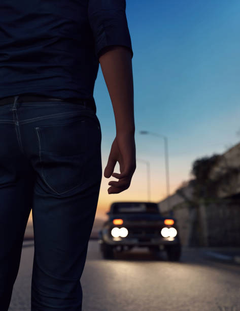 istock Man stands on road with a car with illuminated headlights during twilight. 3D render. 1525143761