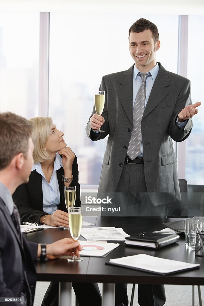 Businessman raising toast with champagne Businessman raising toast with champagne flutes, smiling. Click here for more Business images: Achievement Stock Photo