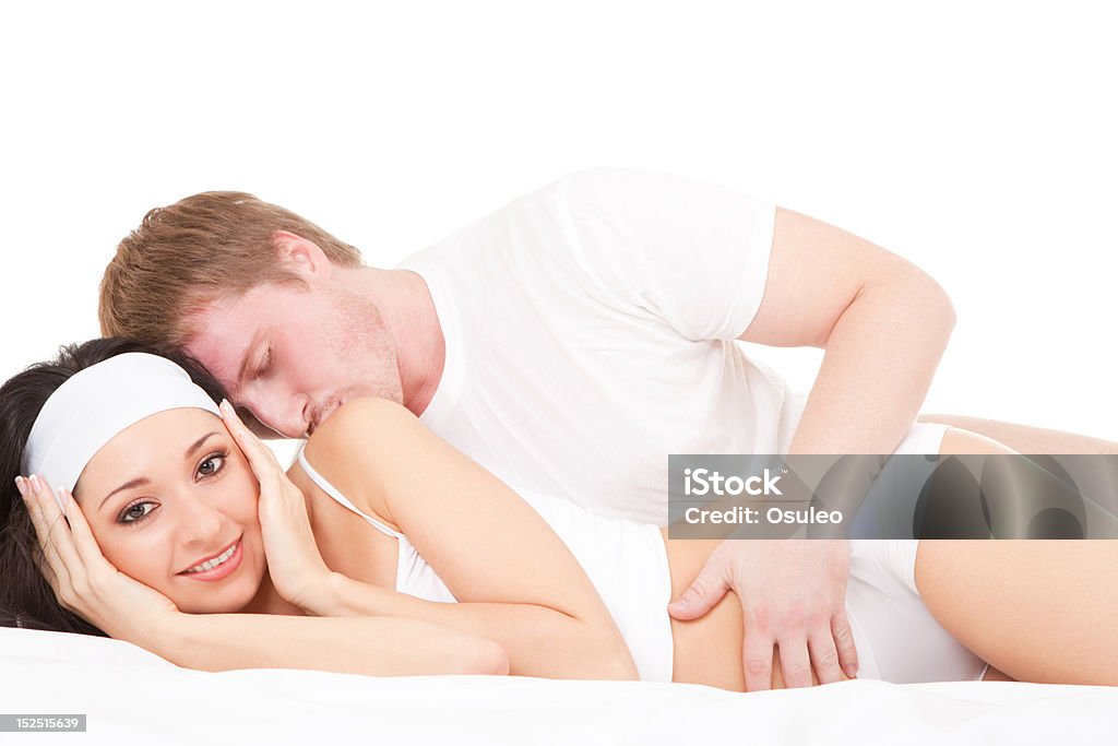 Młoda szczęśliwa para leżąc na łóżku biały - Zbiór zdjęć royalty-free (Biały)